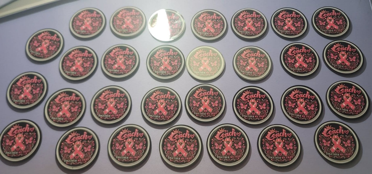Pink ribbon awareness buttons arranged on a table